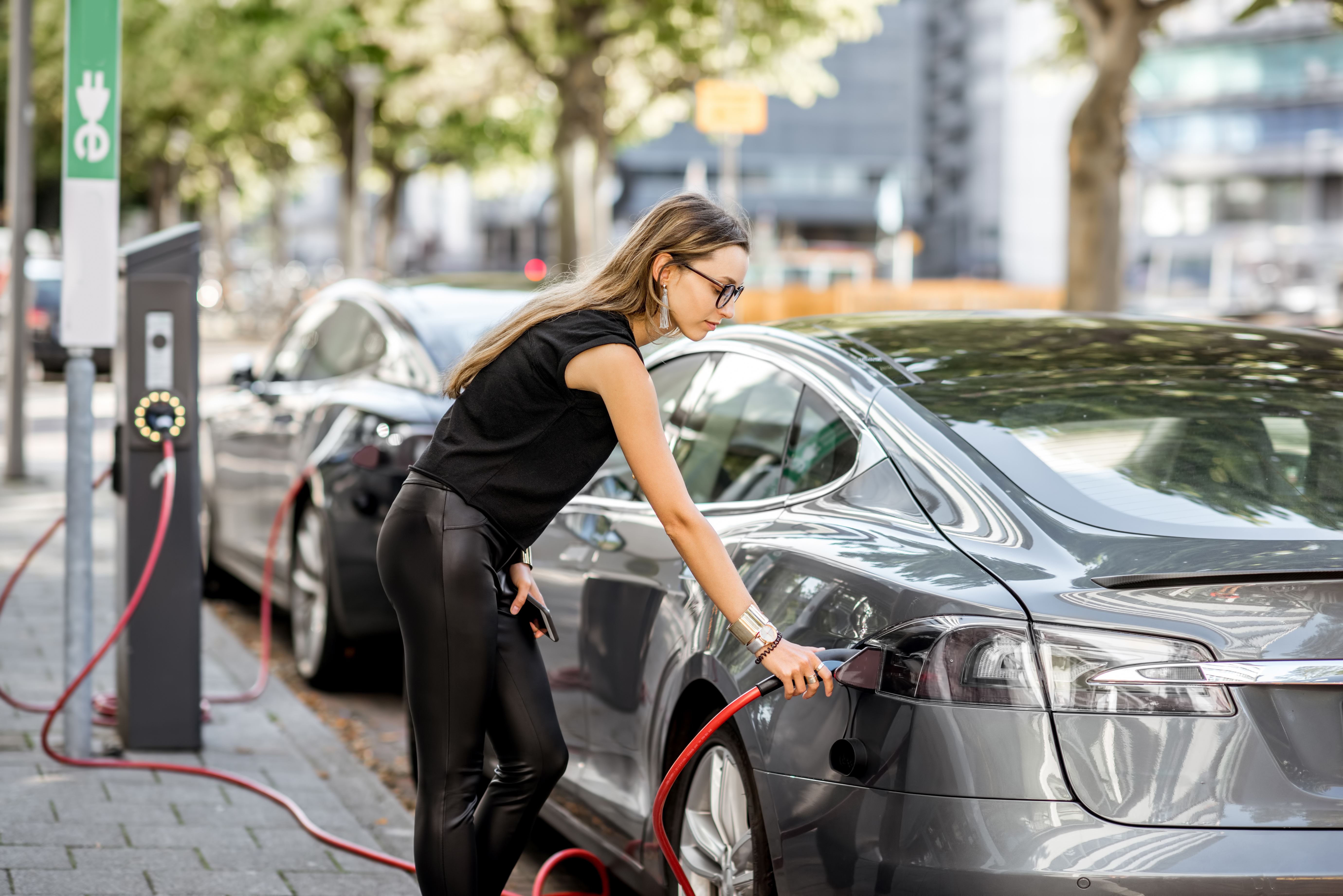 femme rechargeant sa voiture électrique