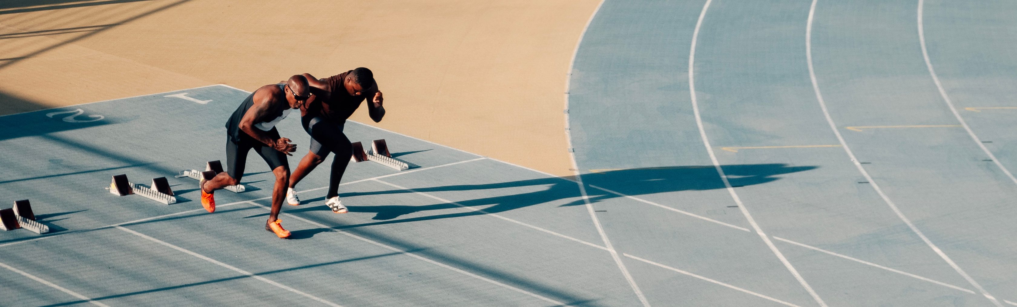  Zwei Athleten beginnen nach Startschuss zu laufen.