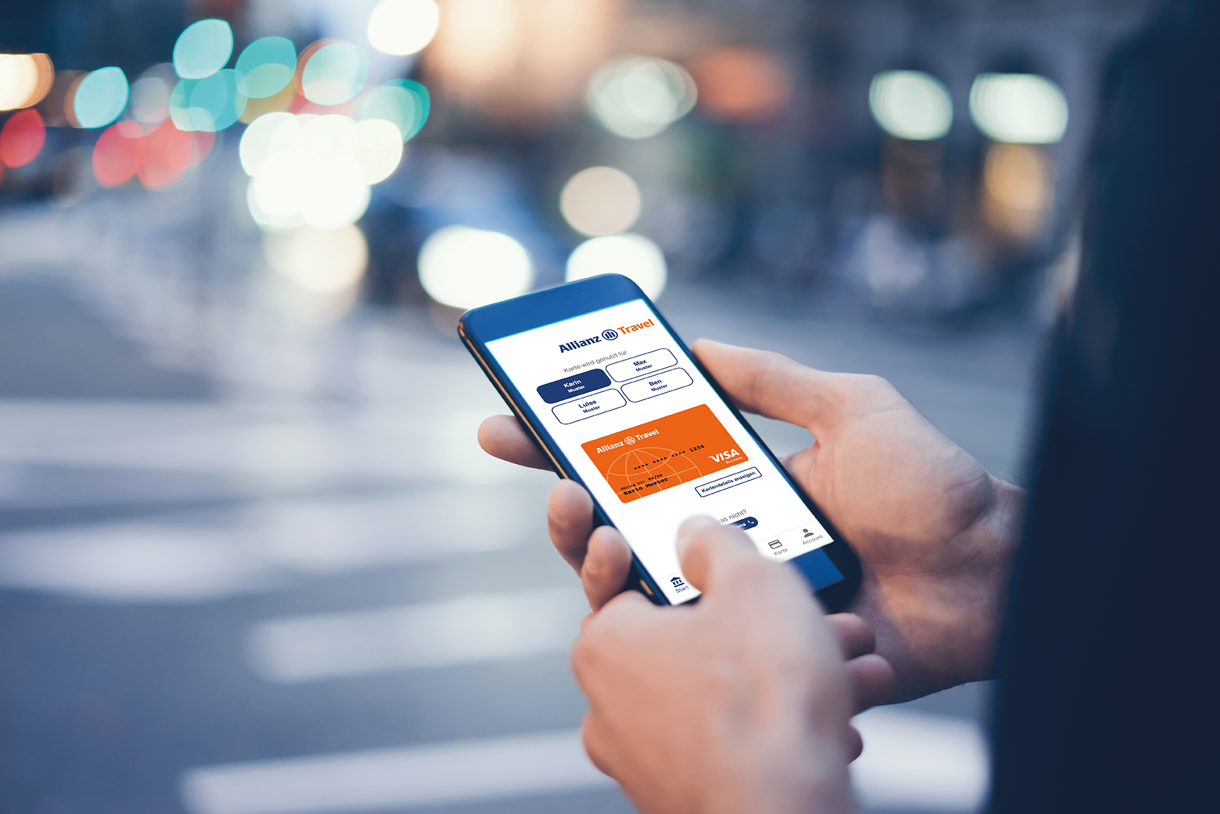 Eine Person benutzt ein Smartphone auf dem die Allianz Travel Visa Card zu sehen ist. Im Hintergrund ist eine Straße mit Autos und verschwommenen Lichtern zu sehen.