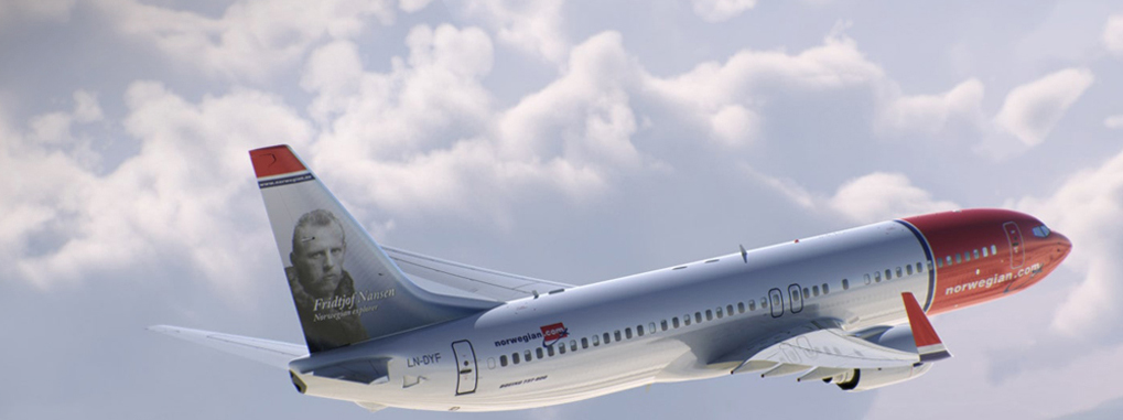 Ein Flugzeug der Norwegian Airline fliegt im Wolkenhimmel.