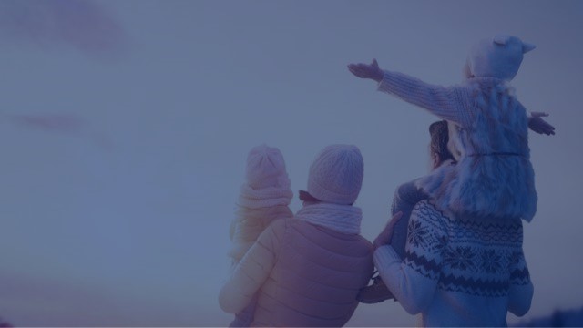 Man sieht eine Familie mit zwei Kindern von hinten.