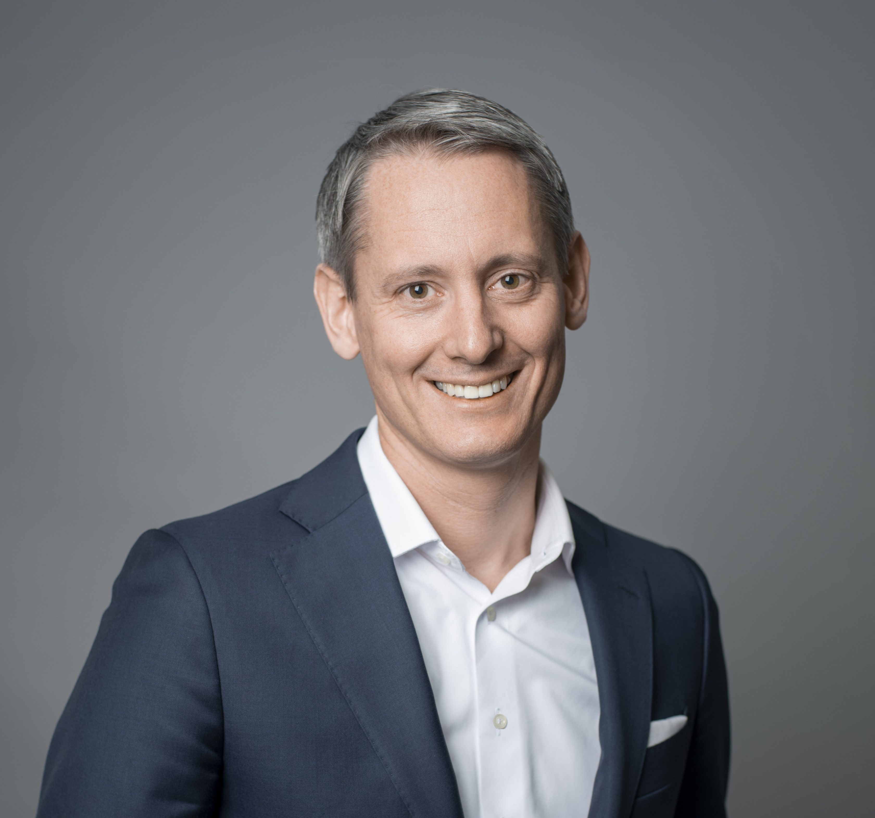 Porträt Jacob Fuest, Chief Markets Officer bei Allianz Partners. Mann mit dunklem Haar, Sakko und weißem Hemd.
