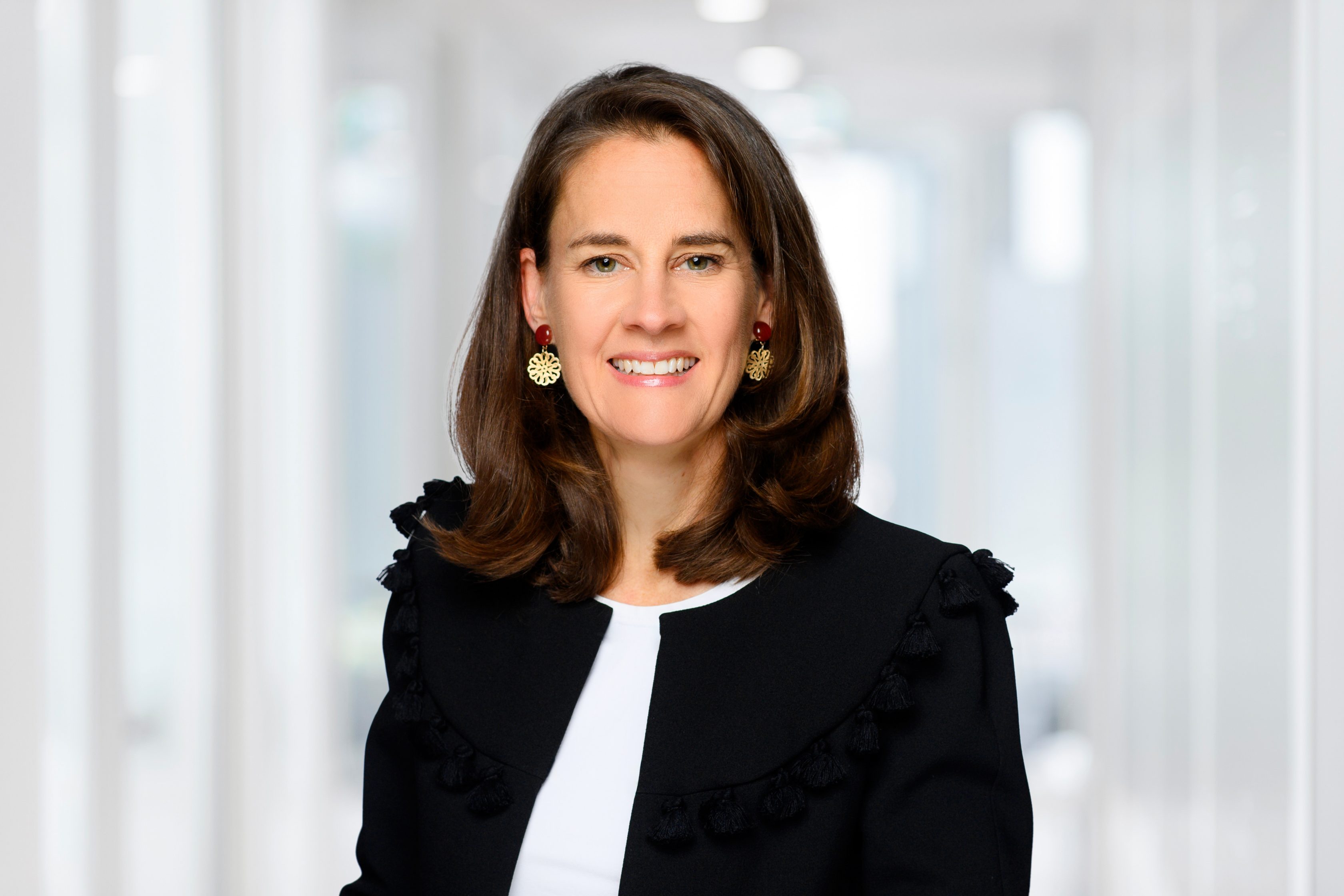 Auf dem Bild ist Stefanie Emde, Head of Operations Mobility & RSA Central & Eastern Europe. Sie hat dunkle, schulterlange Haare, trägt eine schwarze Jacke und eine weiße Bluse und lächelt.