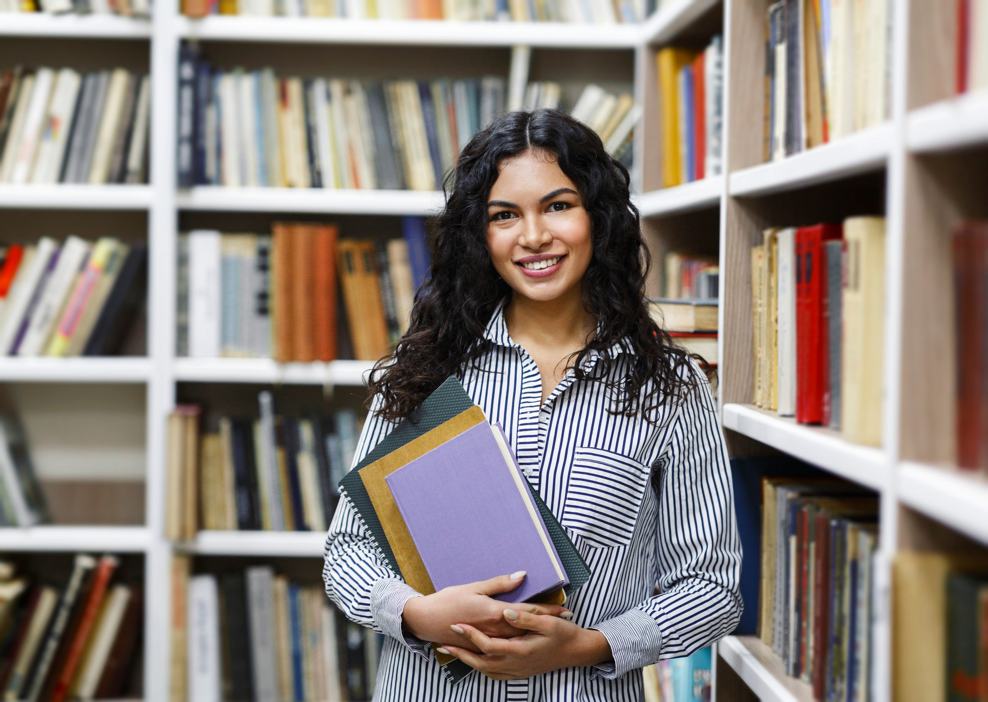 Female international student smiling and standing in a library