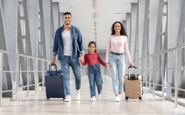 Family walking through an airport together holding hands