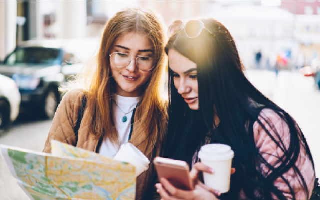 Two female travellers looking at a paper map