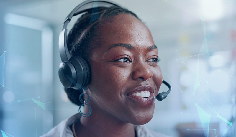 A female in a call centre with a headset on - smiling.