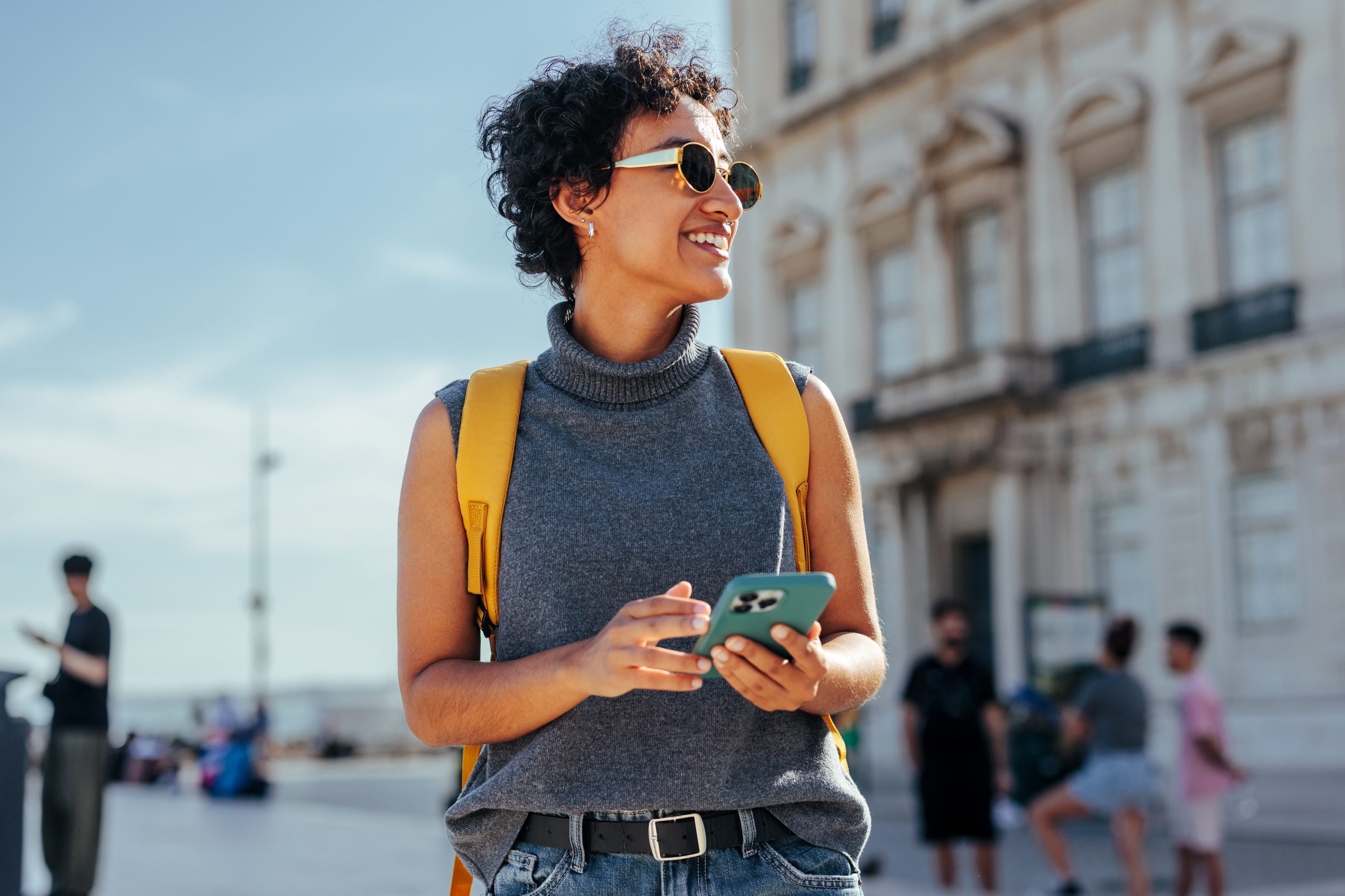 Femme en voyage avec un sac à dos et son téléphone à la main