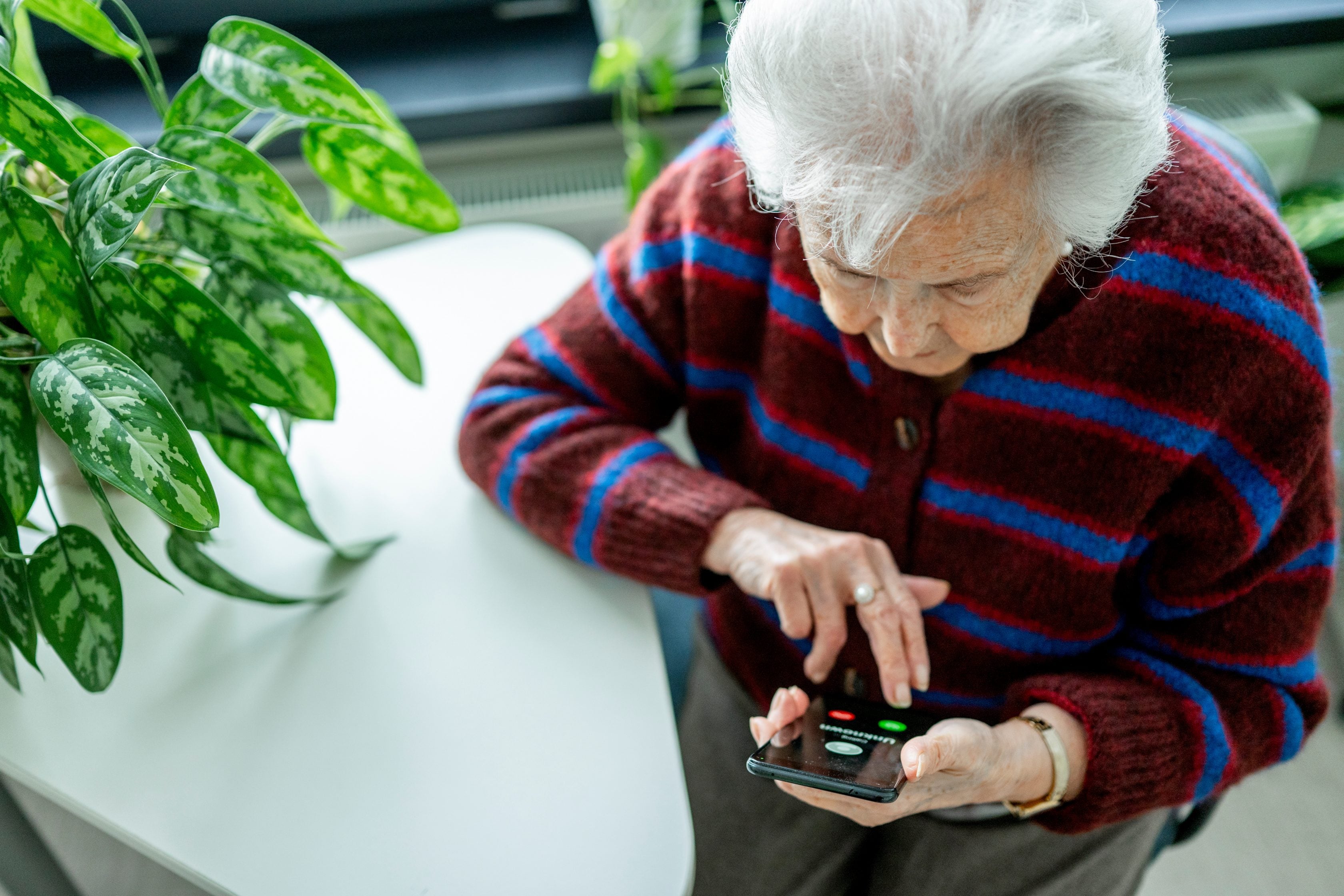Femme âgée assise sur son téléphone portable