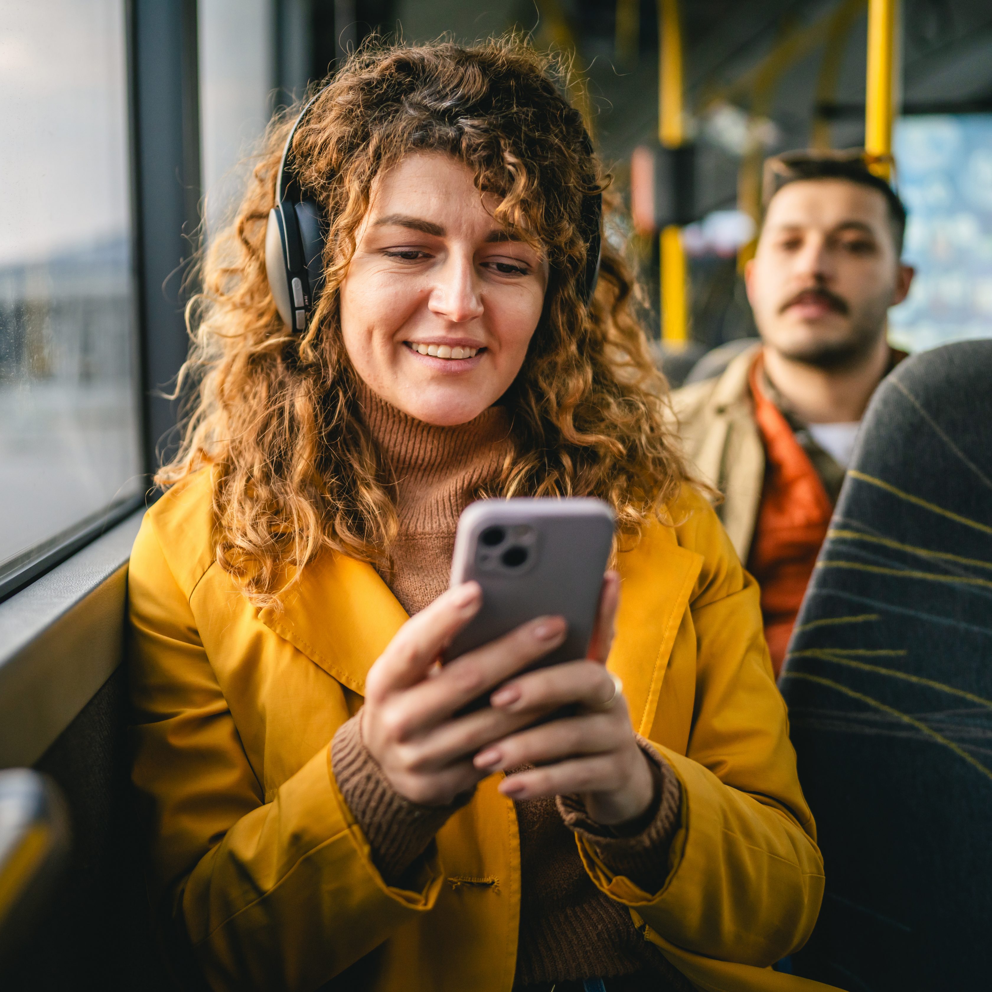 Jeune femme dans les transports en commun en train de regarder son téléphone