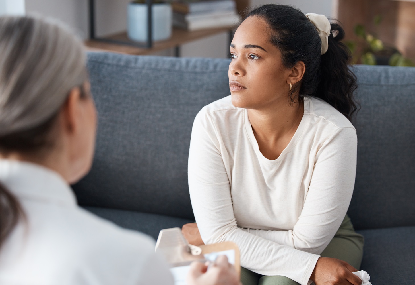 Jeune femme assise sur un canapé en consultation chez un médecin