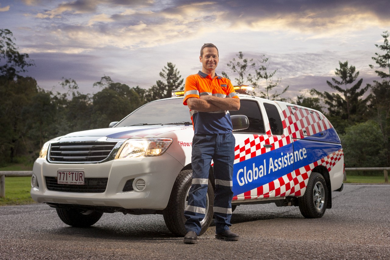 Roadside Assistance technician standing in front of an Allianz vehicle